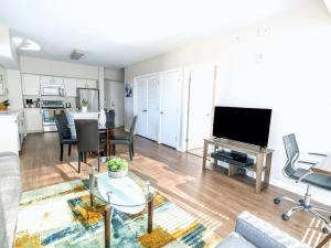 a living room with a flat screen tv and a table at Luxury Apt with High-End Amenities in Stamford
