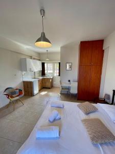 a bedroom with a large bed and a kitchen at A&D Apartments in Porto Rafti