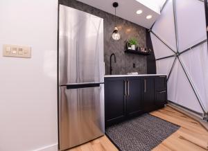 a kitchen with a stainless steel refrigerator in a room at Tranquility Luxe Dome - Hot Tub & Luxury Amenities in Swiss
