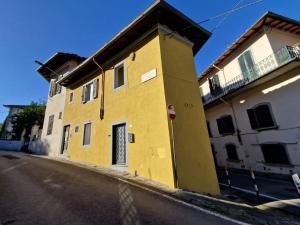 un edificio amarillo al lado de una calle en Angolo al Giardino delle Rose, en Florencia