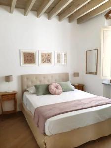 Un dormitorio con una cama grande con una almohada rosa. en Angolo al Giardino delle Rose, en Florencia