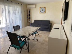 a living room with a table and chairs and a couch at Villa l'Olivier in Cagnes-sur-Mer