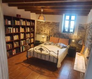 a bedroom with a bed in a room with book shelves at Traditional Stone House in Kissos Pelion in Kissos