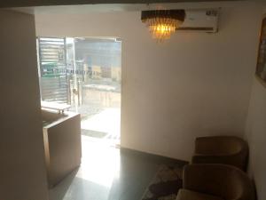 um quarto com um candelabro e duas cadeiras e uma janela em light house hotel lekki phase 1 em Lekki
