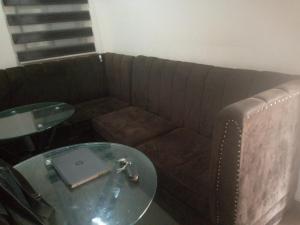 um sofá com uma mesa de vidro num quarto em light house hotel lekki phase 1 em Lekki