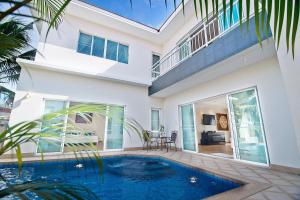a house with a swimming pool in front of it at Tropicana Pool Villa in Jomtien Beach