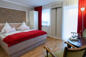 a bedroom with a bed with a red blanket at Gästehaus Nigglhof in Rimsting