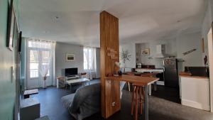 une cuisine et un salon avec une table et un canapé dans l'établissement Le gîte de La Tête de l'Art, à Objat