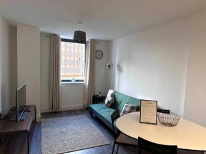 a living room with a couch and a table at Queens House City Centre Apartments in Sheffield