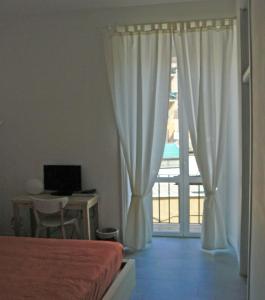 a bedroom with a bed and a window with a balcony at B&b Il Sampietrino Dei Cavalleggeri in Rome