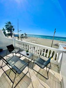 - un balcon avec des chaises, une table et la plage dans l'établissement Apartamento frontal al Mar - Torrox Costa, à Torrox