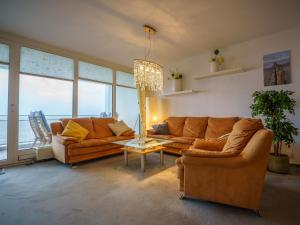 een woonkamer met 2 banken en een tafel bij 143 Fewo-Südstrand-mit-Meerblick in Wilhelmshaven