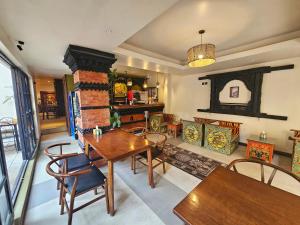 een woonkamer met een tafel en stoelen en een open haard bij SWARGA HERITAGE HOTEL - A TRADITIONAL STAY in Kathmandu