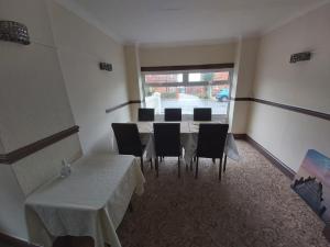 um quarto com uma mesa e cadeiras e uma janela em Channel View Hotel em Sandown