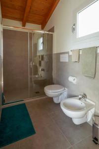 een badkamer met 2 toiletten, een douche en een wastafel bij Casa Selvaggio Blu in Santa Maria Navarrese