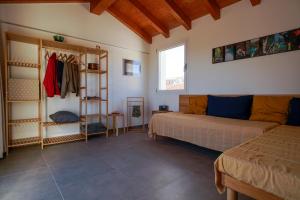 a bedroom with a bed and a couch in a room at Casa Selvaggio Blu in Santa Maria Navarrese