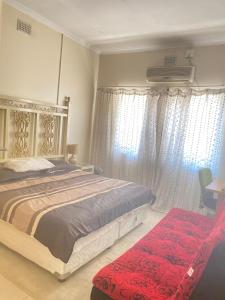 um quarto com uma cama grande, cortinas e uma cadeira. em Hilton inn em Ladysmith