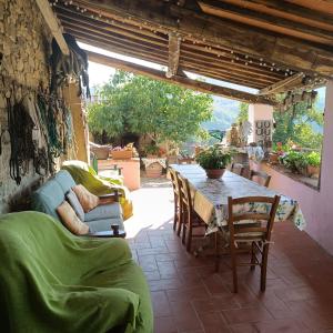 ein Wohnzimmer mit einem Tisch und Stühlen auf einer Terrasse in der Unterkunft Agriturismo Podere Tegline in Radda in Chianti