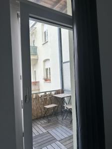 dreams Düsseldorf في دوسلدورف: باب مفتوح للشرفة مع طاولة وكراسي