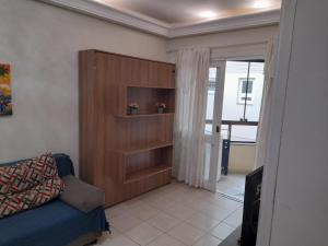 ein Wohnzimmer mit einem blauen Sofa und einem Schrank in der Unterkunft Aluguel Temporada Tramandai Proximo à Praia in Tramandaí