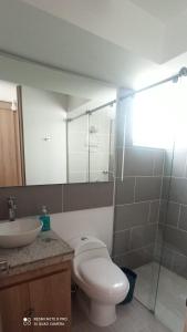 uma casa de banho com um WC e um lavatório em Puerto Azul- Club House. em Ricaurte