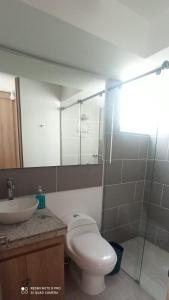 a bathroom with a toilet and a sink at Puerto Azul- Club House. in Ricaurte
