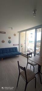 uma sala de estar com um sofá azul e uma mesa e cadeiras em Puerto Azul- Club House. em Ricaurte