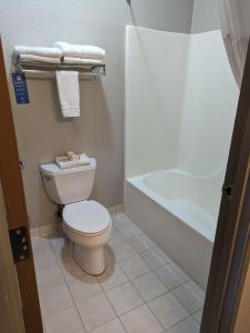 a bathroom with a toilet and a bath tub at Days Inn & Suites by Wyndham Castle Rock in Castle Rock