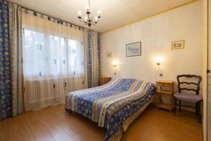 1 dormitorio con 1 cama, 1 silla y 1 ventana en LE COTEAU Pavillon au calme 2 chambres 4-5 personnes, en Savigny-sur-Orge