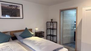 a bedroom with a bed and a walk in shower at Heimatliebe Erfweiler Wohnung VIER in Erfweiler