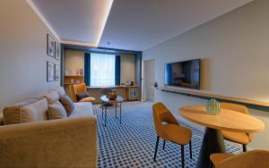 ein Wohnzimmer mit Sofa und Tisch in der Unterkunft Novotel Luxembourg Kirchberg in Luxemburg (Stadt)