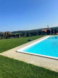 a swimming pool in a grassy field next to a field at Villa Cariño - Apartamento en Malpica de Bergantiños in Malpica