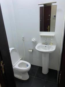 a white bathroom with a toilet and a sink at Harmonie ville in Dakar