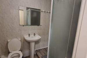 a bathroom with a toilet and a sink and a mirror at Radcliffe Studio in Nottingham