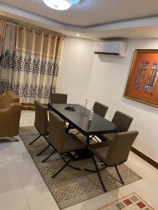 a dining room with a black table and chairs at Harmonie ville in Dakar