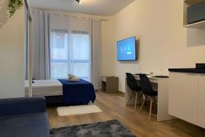 a living room with a blue table and a window at Studio Vila Prudente - Metrô linha verde in São Paulo