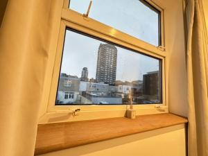 ein Fenster mit Blick auf die Skyline der Stadt in der Unterkunft Large En-Suite Studio with private bath and kitchen In Canary Wharf 4 in London