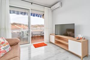 sala de estar con TV de pantalla plana y sofá en Bonito Apartamento Costa Tropical, en Polopos