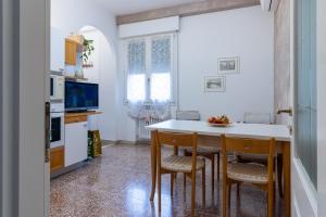 kuchnia ze stołem i krzesłami oraz kuchnia z telewizorem w obiekcie HouSmart Galeotti 16 w Bolonii