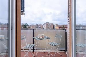 balkon ze stołem i krzesłami w obiekcie HouSmart Galeotti 16 w Bolonii