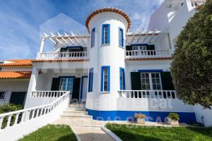 een wit huis met blauwe rand en trappen bij Casa Sardine by ACasaDasCasas in Ericeira