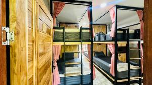 2 Etagenbetten in einem Zimmer mit einer Tür in der Unterkunft Koh Tao Silver Na’s Hostel in Ko Tao