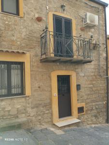 a stone building with a balcony and a door at Casa rosy in Caltanissetta