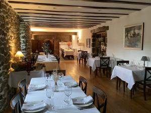 a restaurant with tables and chairs with white tablecloths at Goiko-Benta Ostatua in Oñate