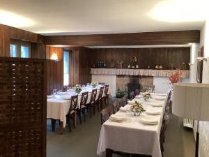 a dining room with white tables and chairs and a fireplace at Goiko-Benta Ostatua in Oñati