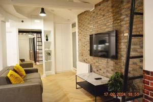 a living room with a couch and a brick wall at Magnificient Parisian Flat - Parisian heart in Paris