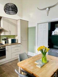 a kitchen with a wooden table with flowers in a vase at The Old Schoolhouse, Kinross in Kinross