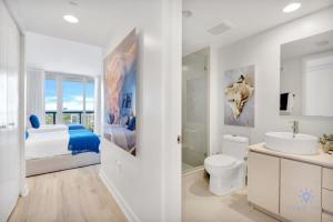 a white bathroom with a bed and a sink at Spectacular View with Balcony, Pool, Near Beach in Hallandale Beach