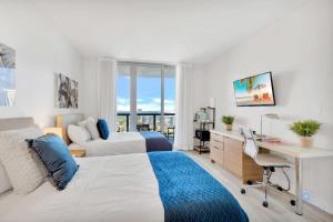a bedroom with a bed and a desk with a desk at Spectacular View with Balcony, Pool, Near Beach in Hallandale Beach