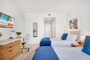 a hotel room with two beds and a desk at Spectacular View with Balcony, Pool, Near Beach in Hallandale Beach